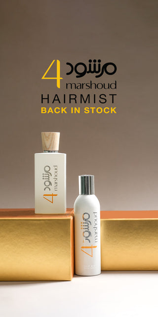 Two bottles of Atyab Al Marshoud 4 Hair Mist and Marshoud 4 white perfume displayed on a golden platform with Arabic and English branding, featuring the text 'Hairmist Back in Stock' on a beige background