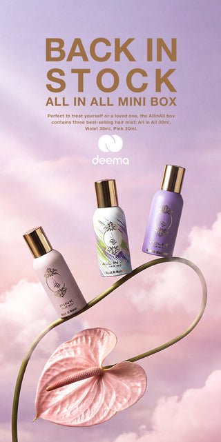 Promotional graphic for the deema All In All Mini Box, featuring three mini skincare bottles (pink, white/green, and purple) with gold caps floating above a pink anthurium flower on a curved green stem against a pastel pink and purple cloudy sky background. The text reads 'BACK IN STOCK ALL IN ALL MINI BOX' with the deema logo.