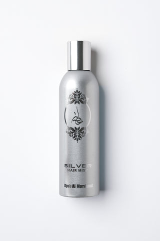 Silver hair mist bottle with decorative label on a white background by Atyab Al Marshoud