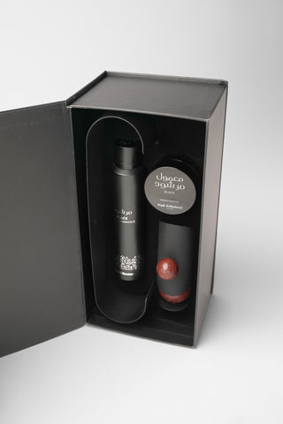 Black bottle and red cap in a black box on a white background by Atyab Al Marshoud.